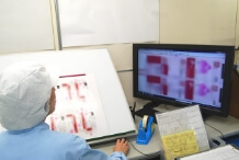 印刷物とデータを目視で検査している写真